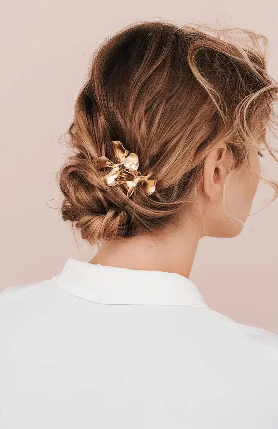 Messy twisted low bun and waves on top plus waves on the front and some floral hair pins.
