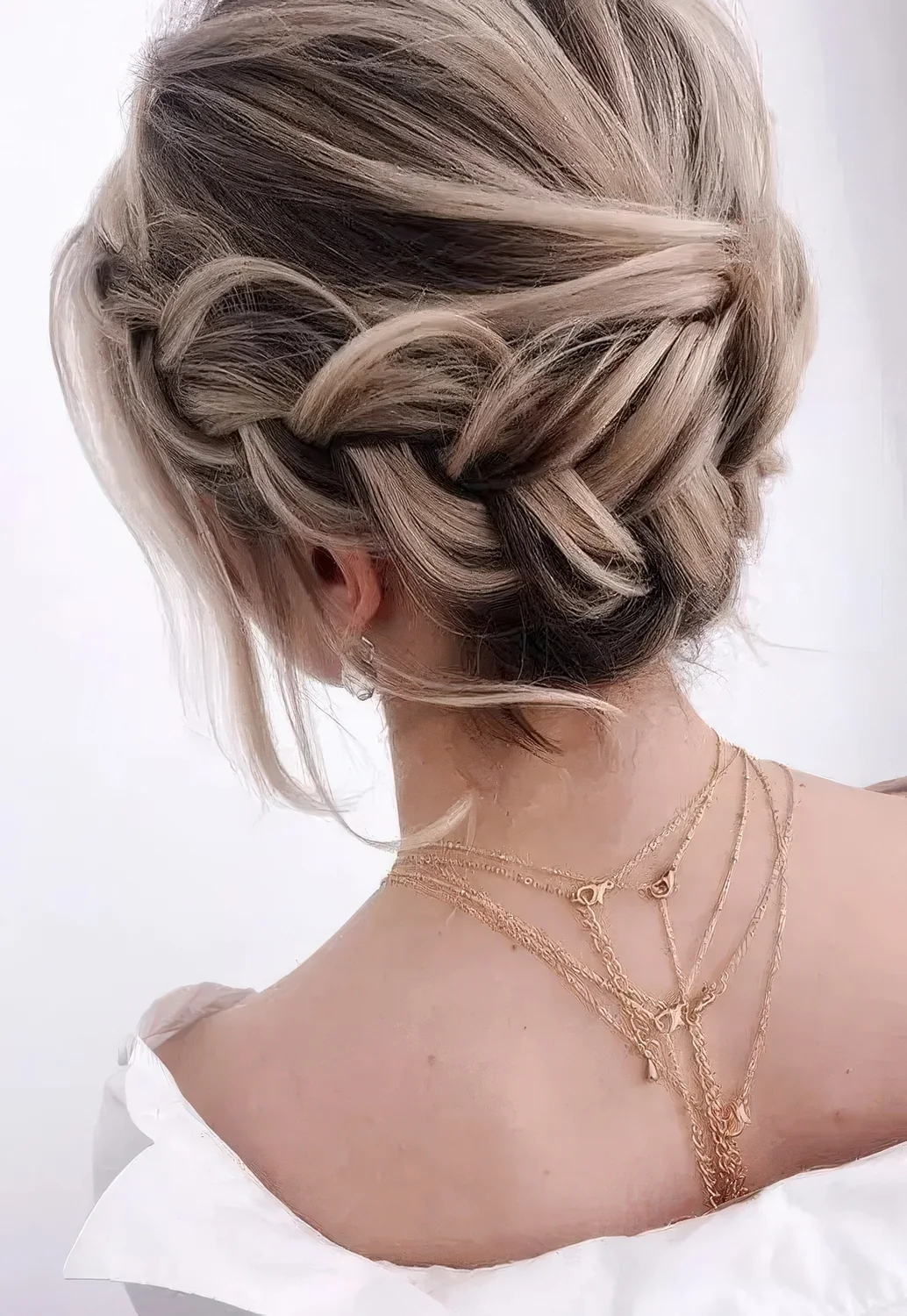 Braided halo low updo with a volume on top, some waves down.