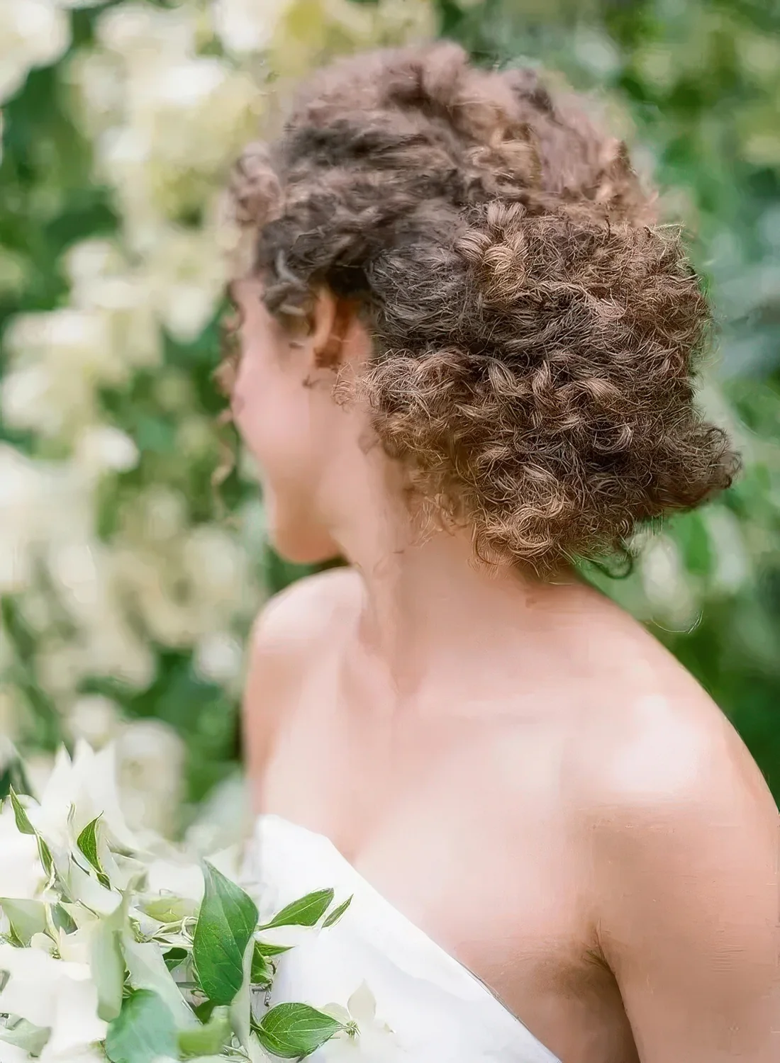 Braided low updo with natural curls.