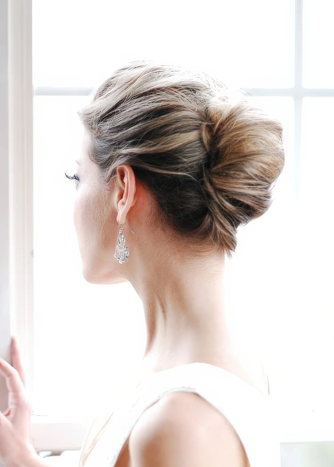 Classic chingon wedding updo with a messy volumetric top.