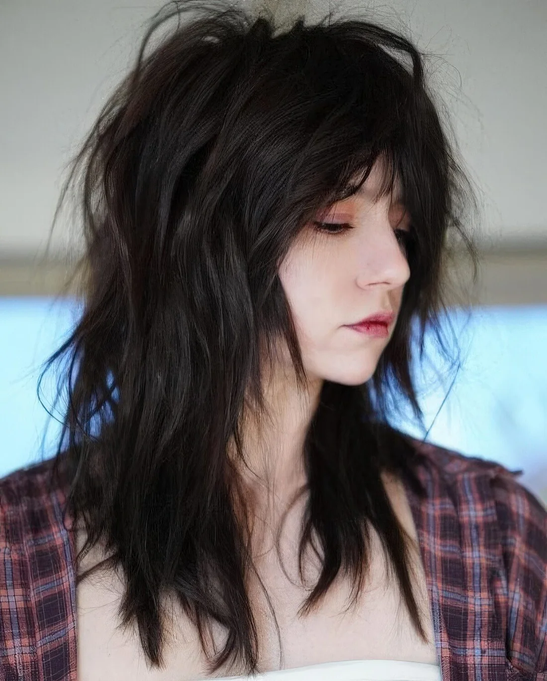 Black and super messy and textural wolf cut with a lot of volume.