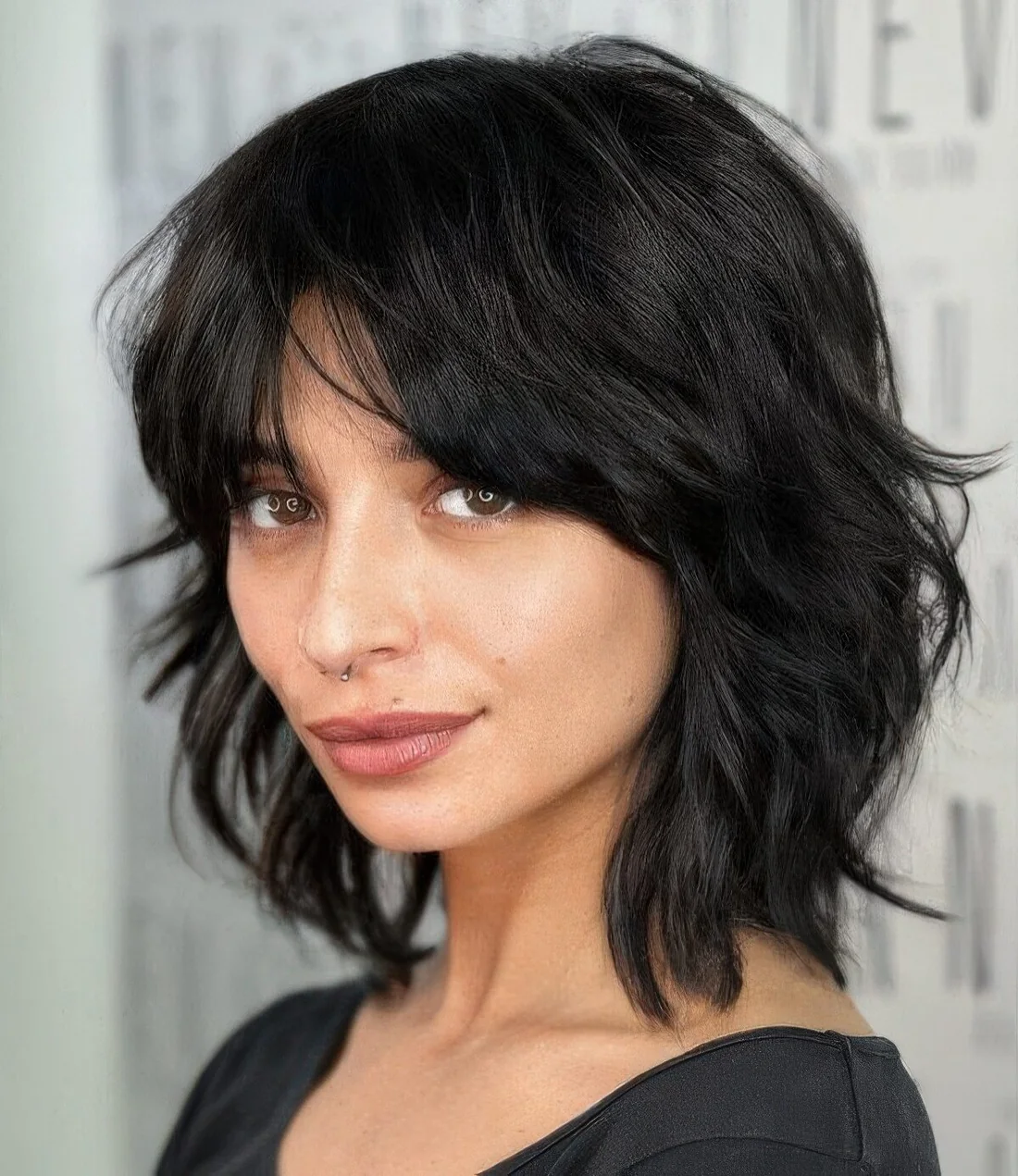 Black medium wolf cut with messy styling and bottleneck bangs.
