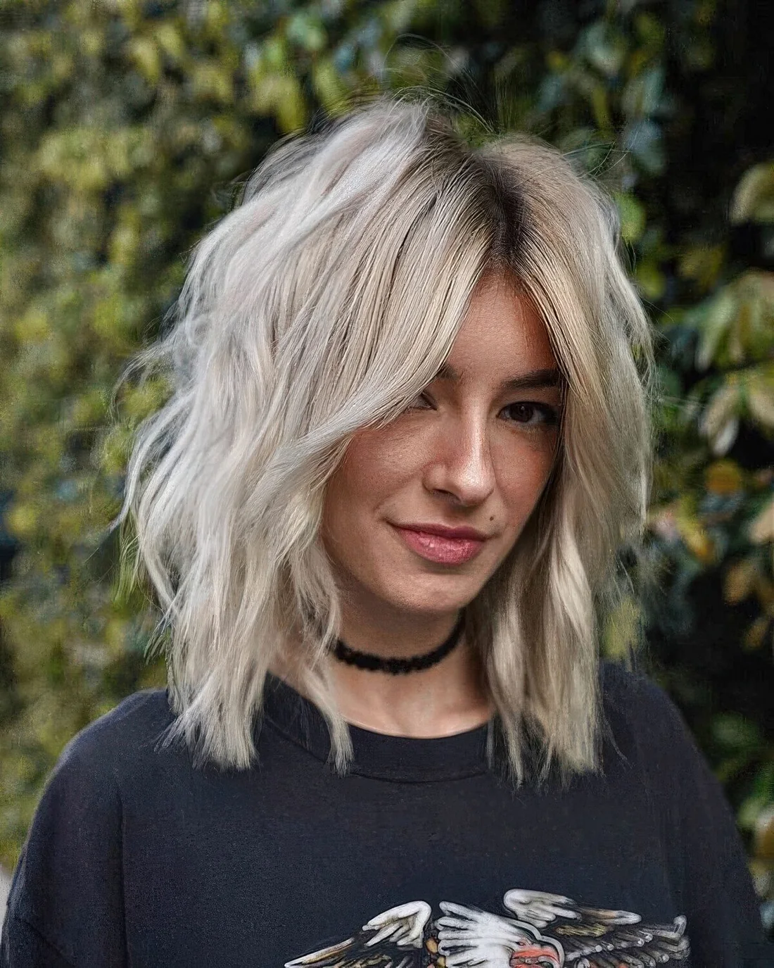 Blonde medium wolf cut with a softer shape, a darker root and some messy texture.
