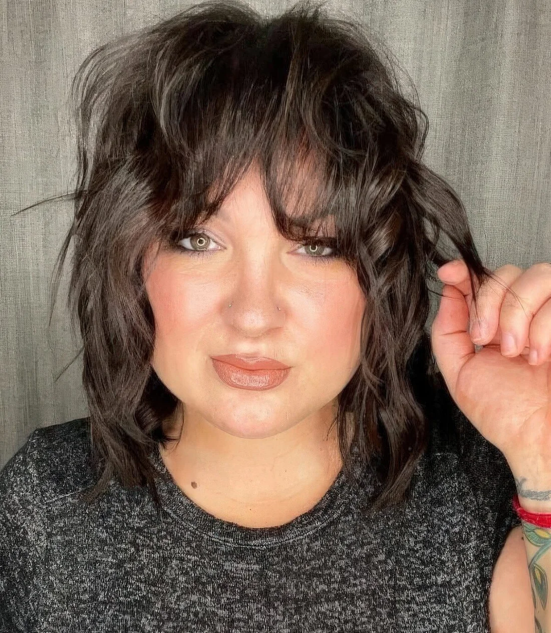 Brown thin wavy wolf cut with bottleneck bangs allows to create a volume and.