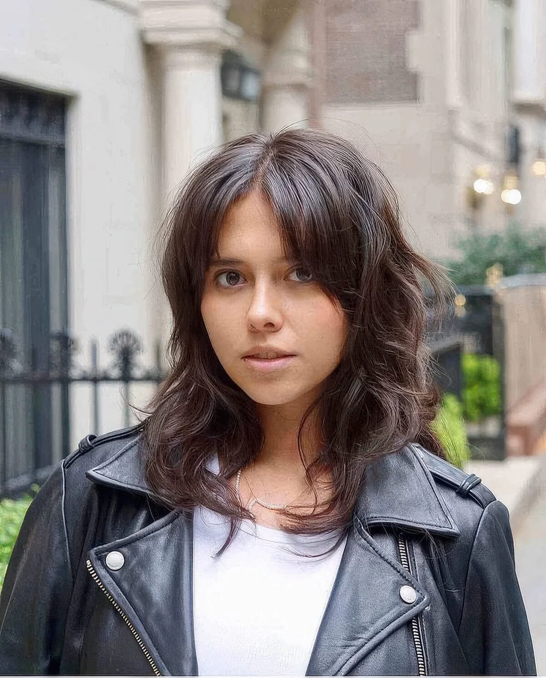 Dark brunette medium wolf cut with curtain bangs and waves.