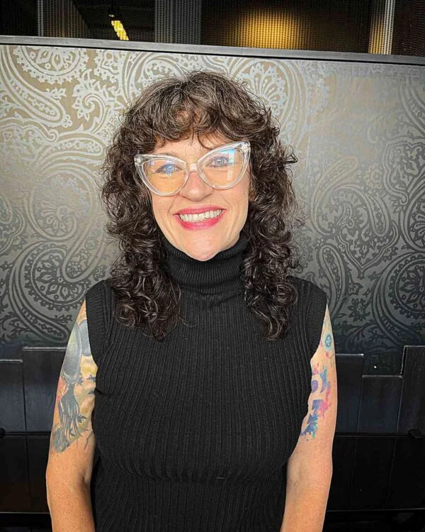 shoulder curly brunette shag with curly fringe fringe shown as a messy haircuts for women over 60 idea, featuring volume through the all over