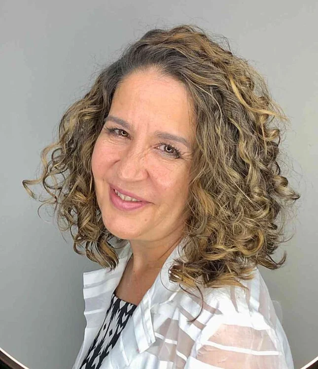 shoulder curly chestnut shag with curly fringe fringe shown as a messy haircuts for women over 60 idea