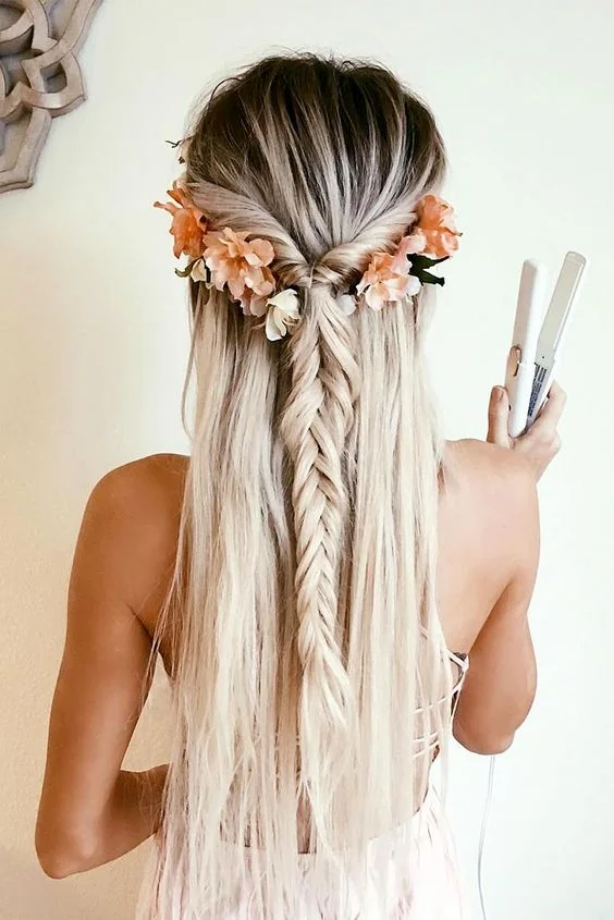 Half updo with a loose fishtail braid and some flowers.