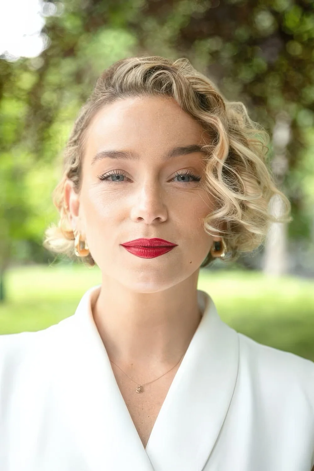 Exquisite blonde curly short bob with side part.