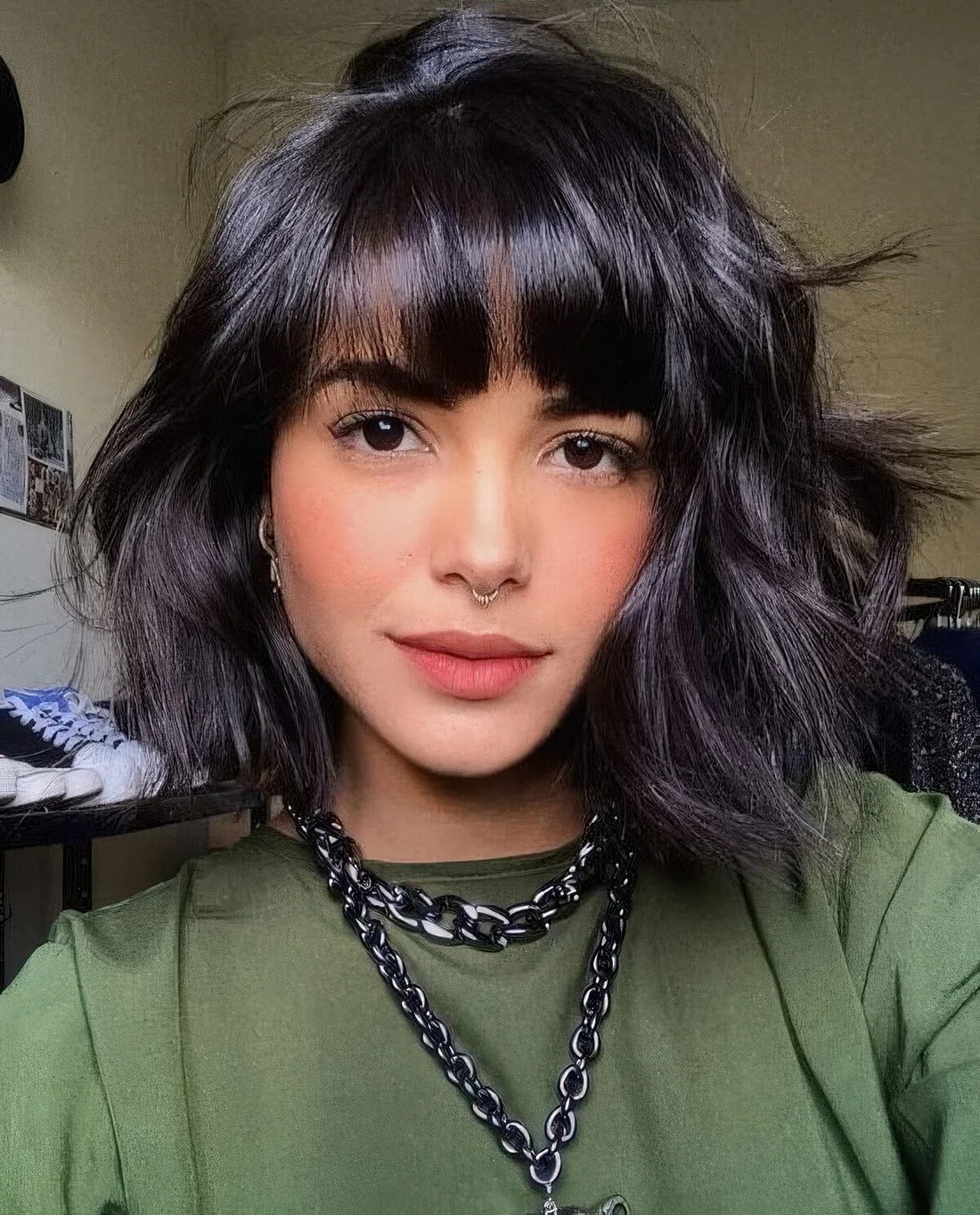 Black messy wavy chin-length bob with fringe bangs.