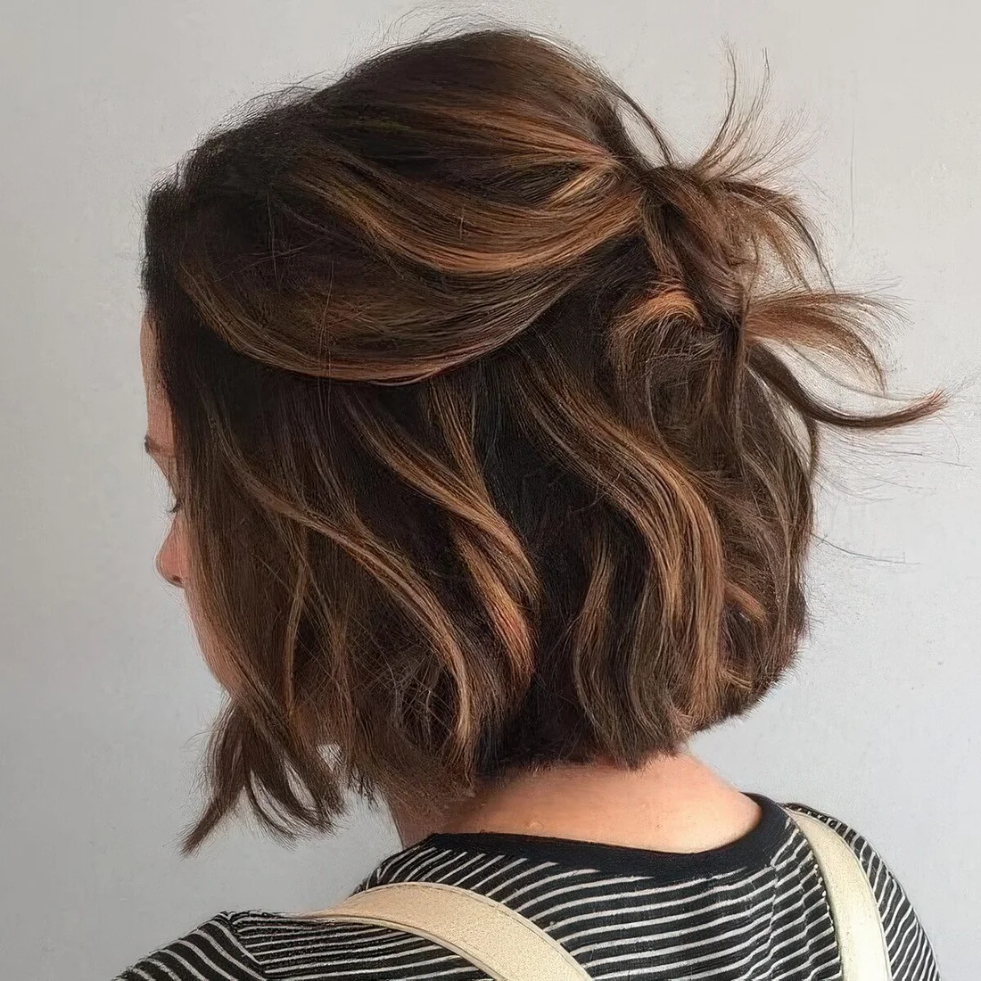 Black bob done with caramel balayage, with a lot of volume, waves.