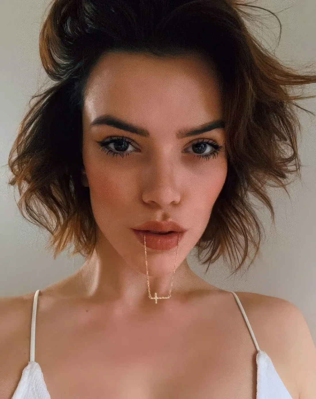 Flipped shaggy brown bob with messy texture and waves change the parting as you like.