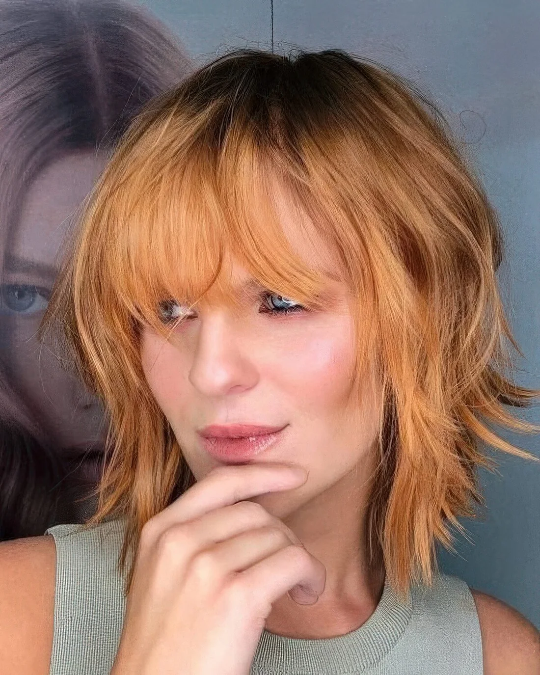 Ginger shaggy medium bob with a darker root and a fringe.