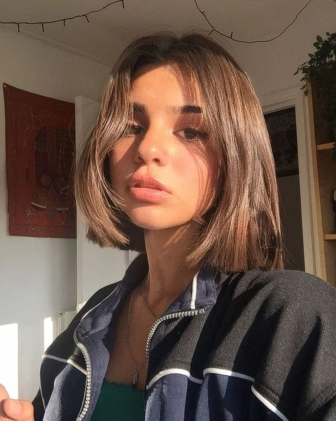 Liquid brown bob with side bangs, a voluminous root and center part.