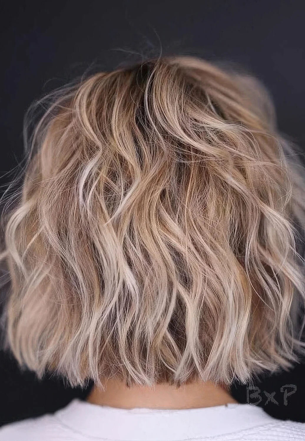 Blonde balayage choppy bob with waves.