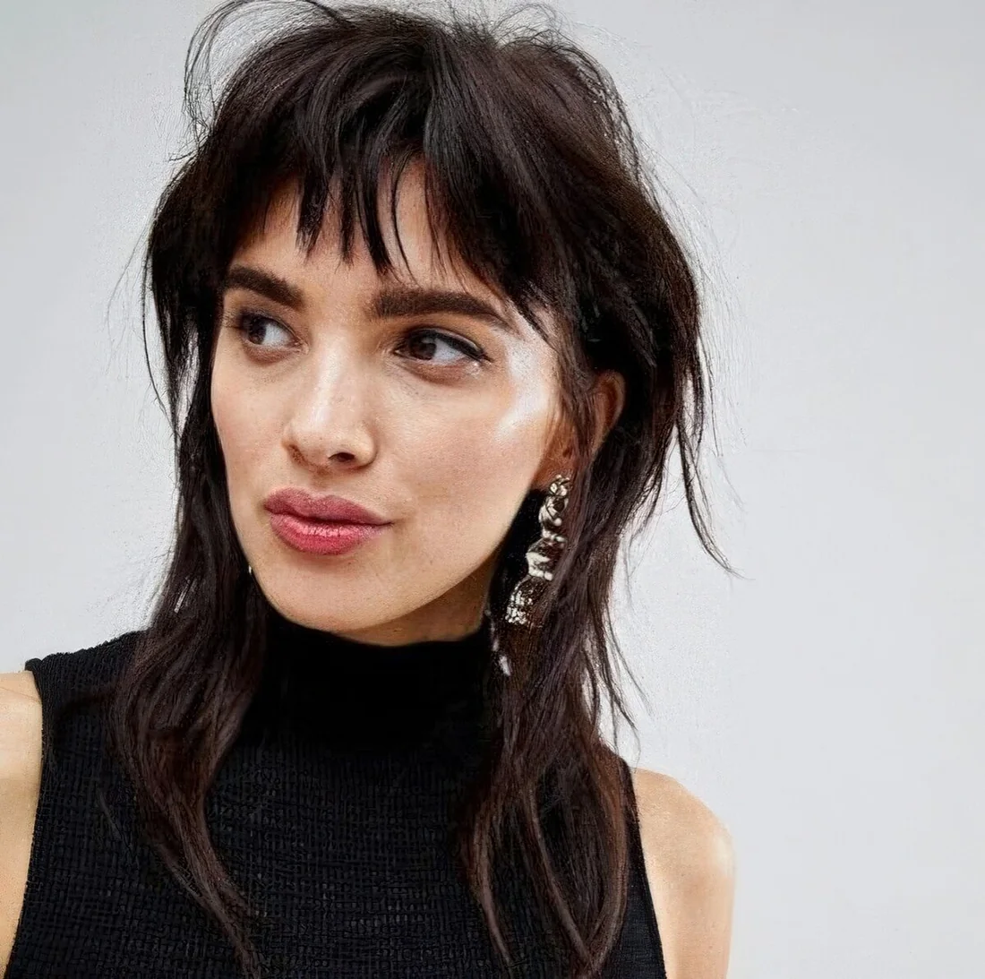 Mullet haircut in a dark chestnut shade, with fringe and shoulder-length.