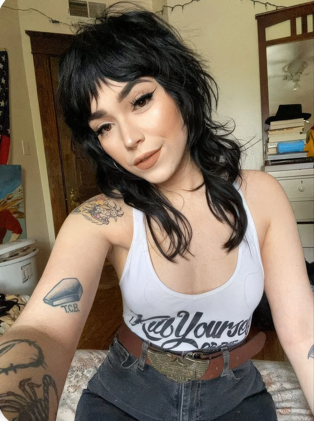 Black shaggy long mullet with wispy bangs and long and messy hair on the back and sides.