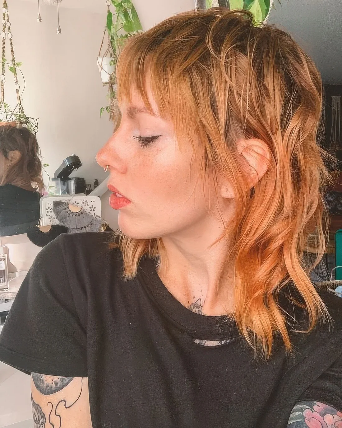 Ginger mullet with shaggy touches, with bangs, shorter hair on top and longer hair on the back and sides.