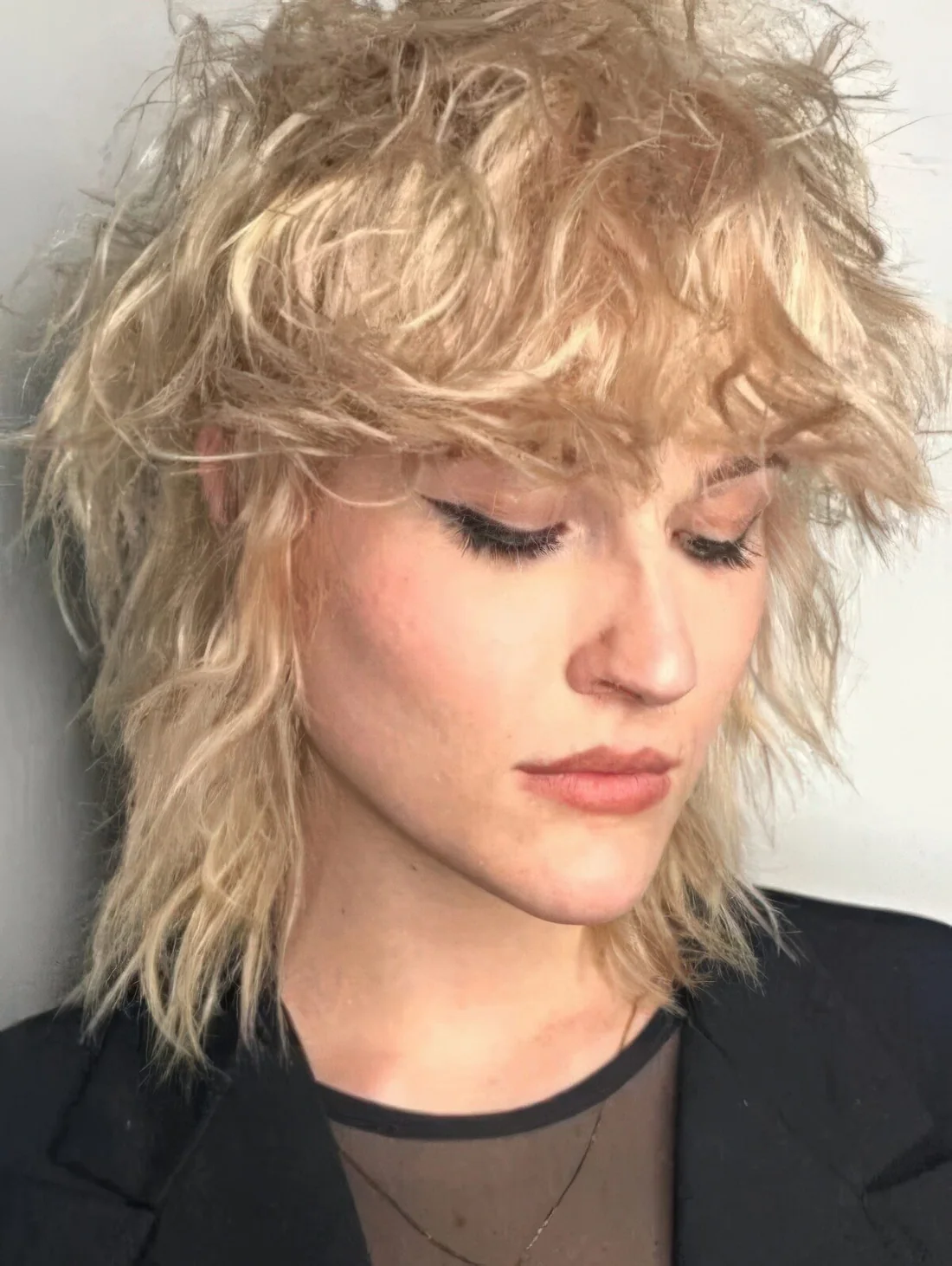 Photo showing messy and textural blonde mullet, with the hairstyle clearly visible.