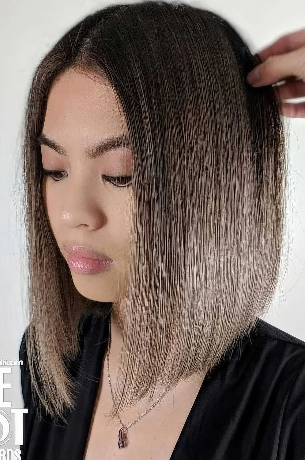 Blunt bob with a black root and mousy brown ombre hair.
