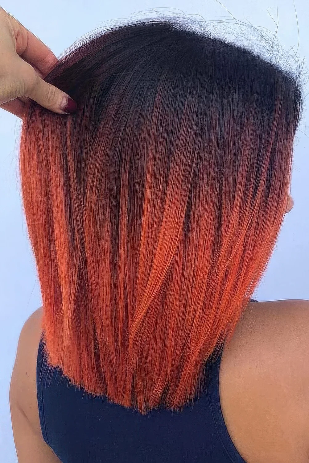 Long bob with an ombre effect, from black to hot red, with a lot of volume.