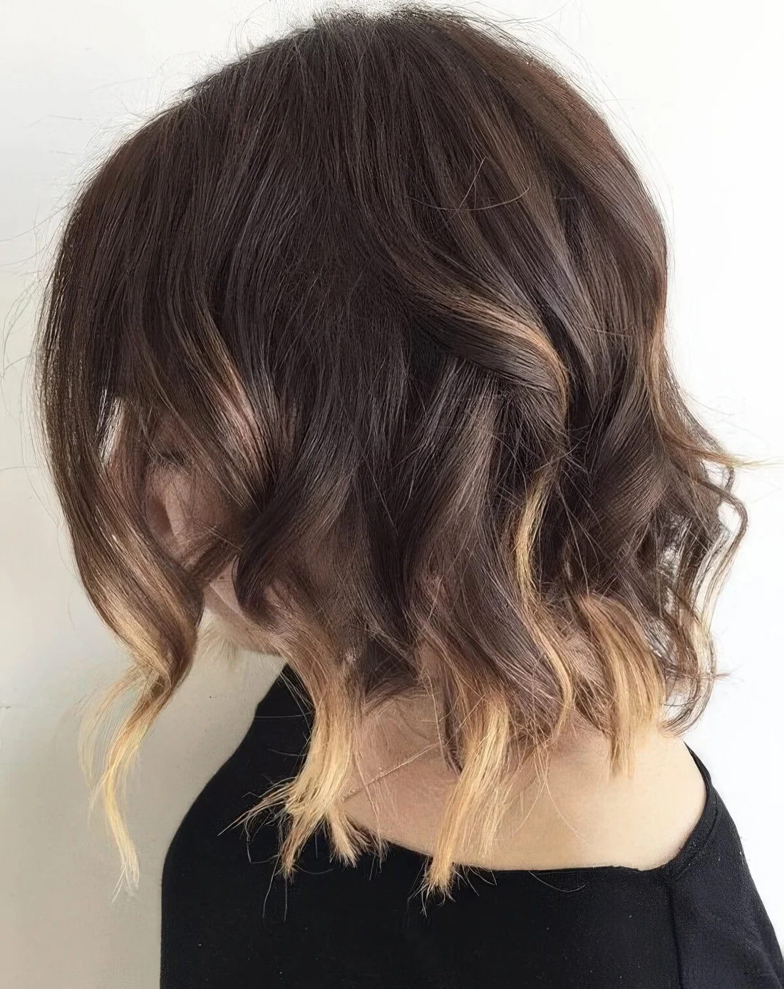 Long and wavy bob with blonde ombre touches and a lot of volume.