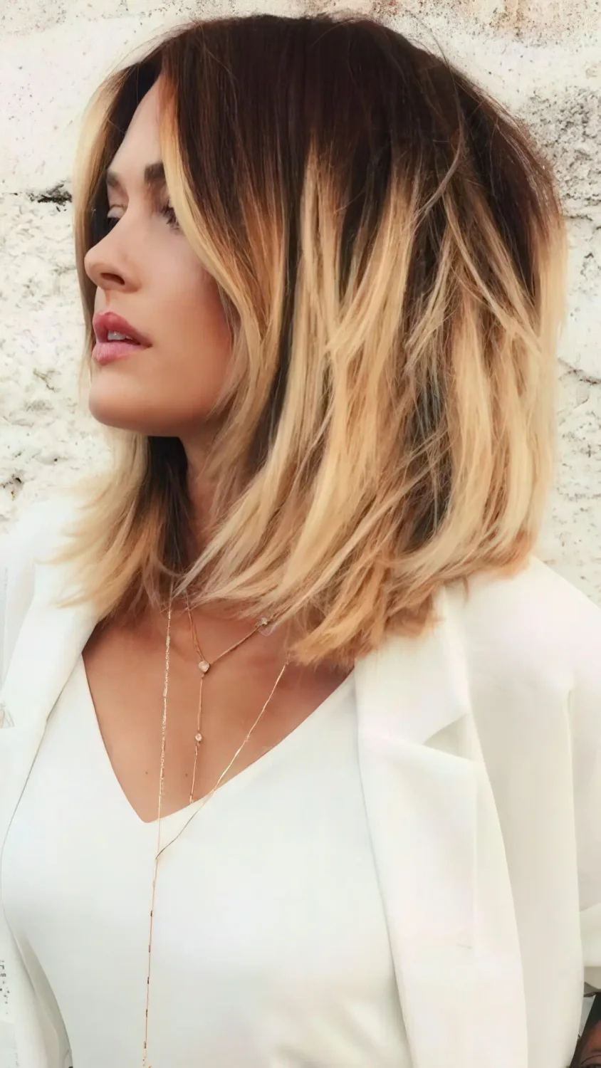 Textural bob, black roots, warm blonde to caramel edges for a sunburnt look.