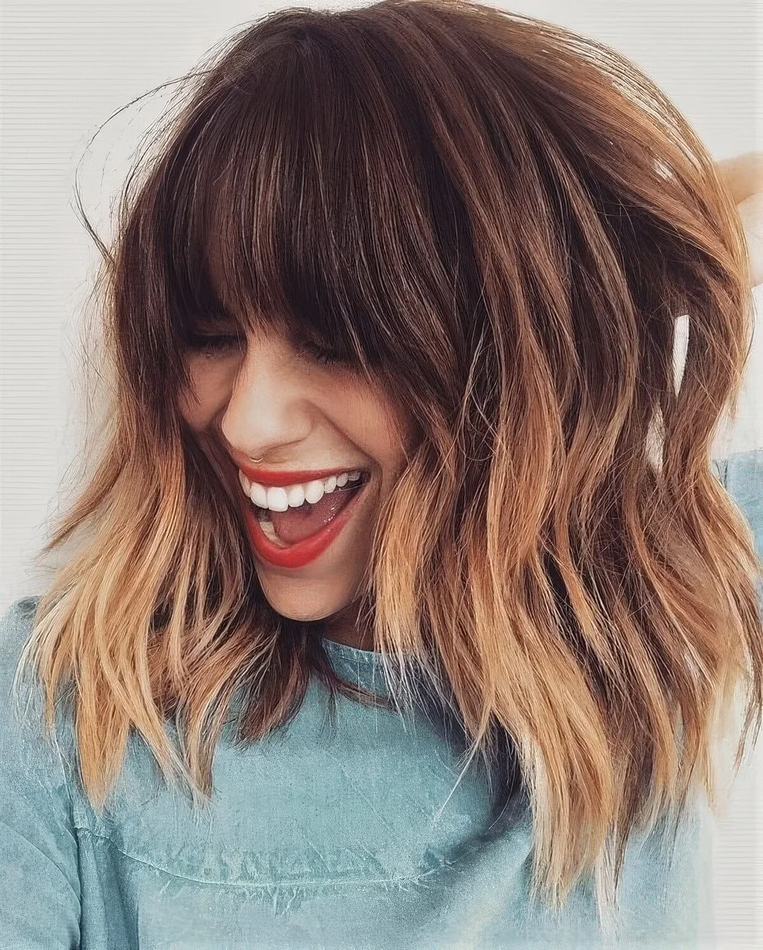 Brown layered outgrown bob with copper highlights and with classic and face-framing bangs.
