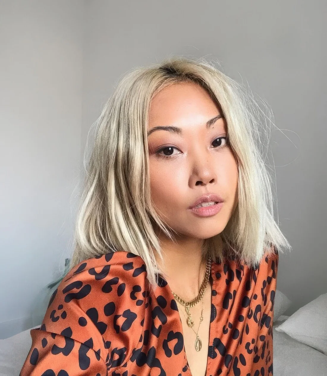 Creamy blonde outgrown bob with middle part and texture, with side bangs.