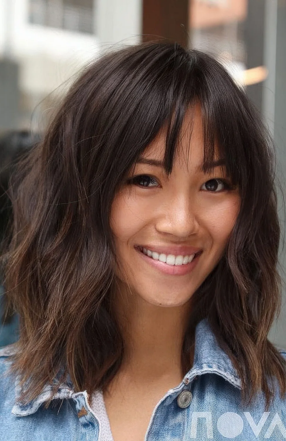 Layered outgrown bob with bottleneck bangs and a rich brown tone.