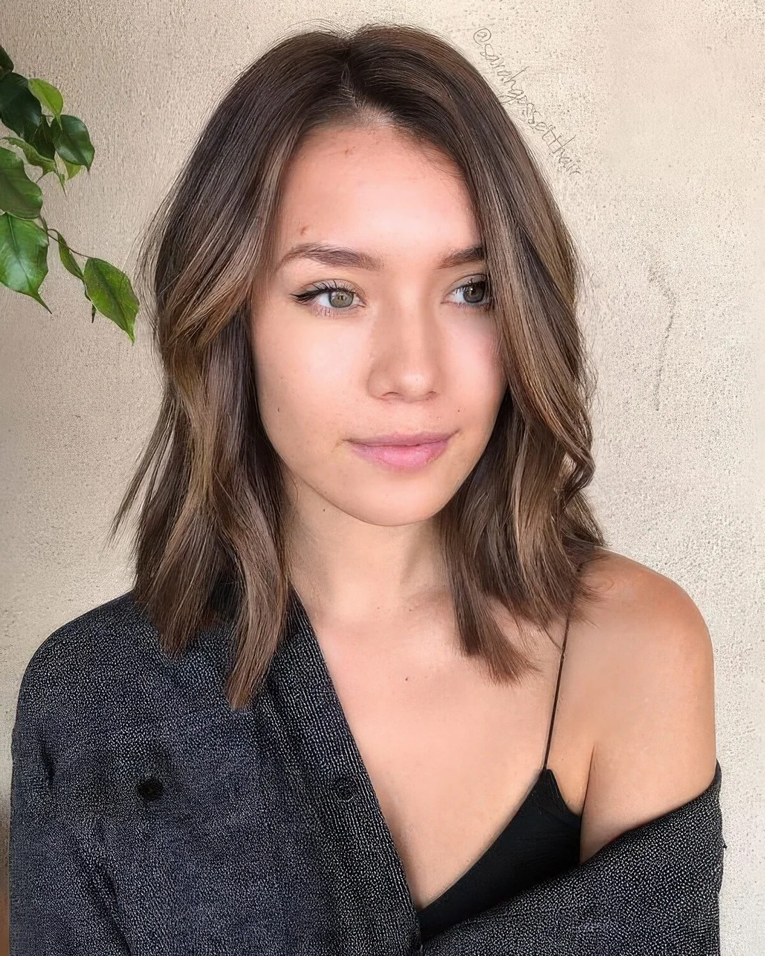 Brown outgrown bob with side part and caramel balayage, with a bit of waves.