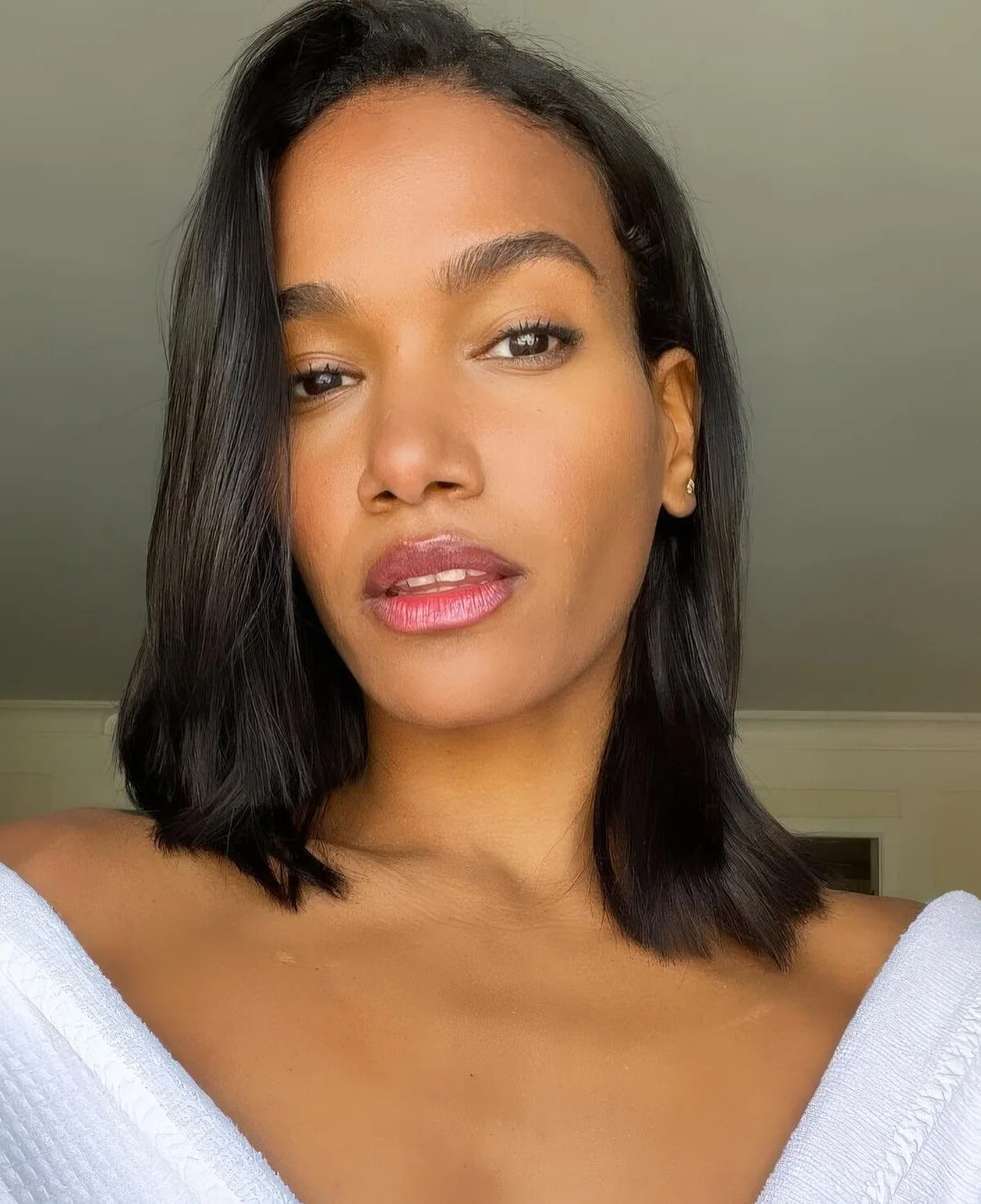 Sleek and straight black outgrown bob with side part and beautiful and shiny hair.