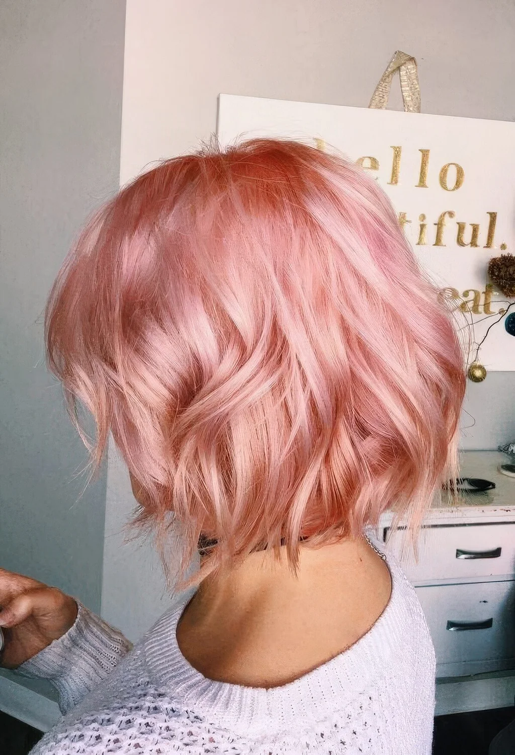 Pastel pink shaggy midi bob with waves and a shiny finish.