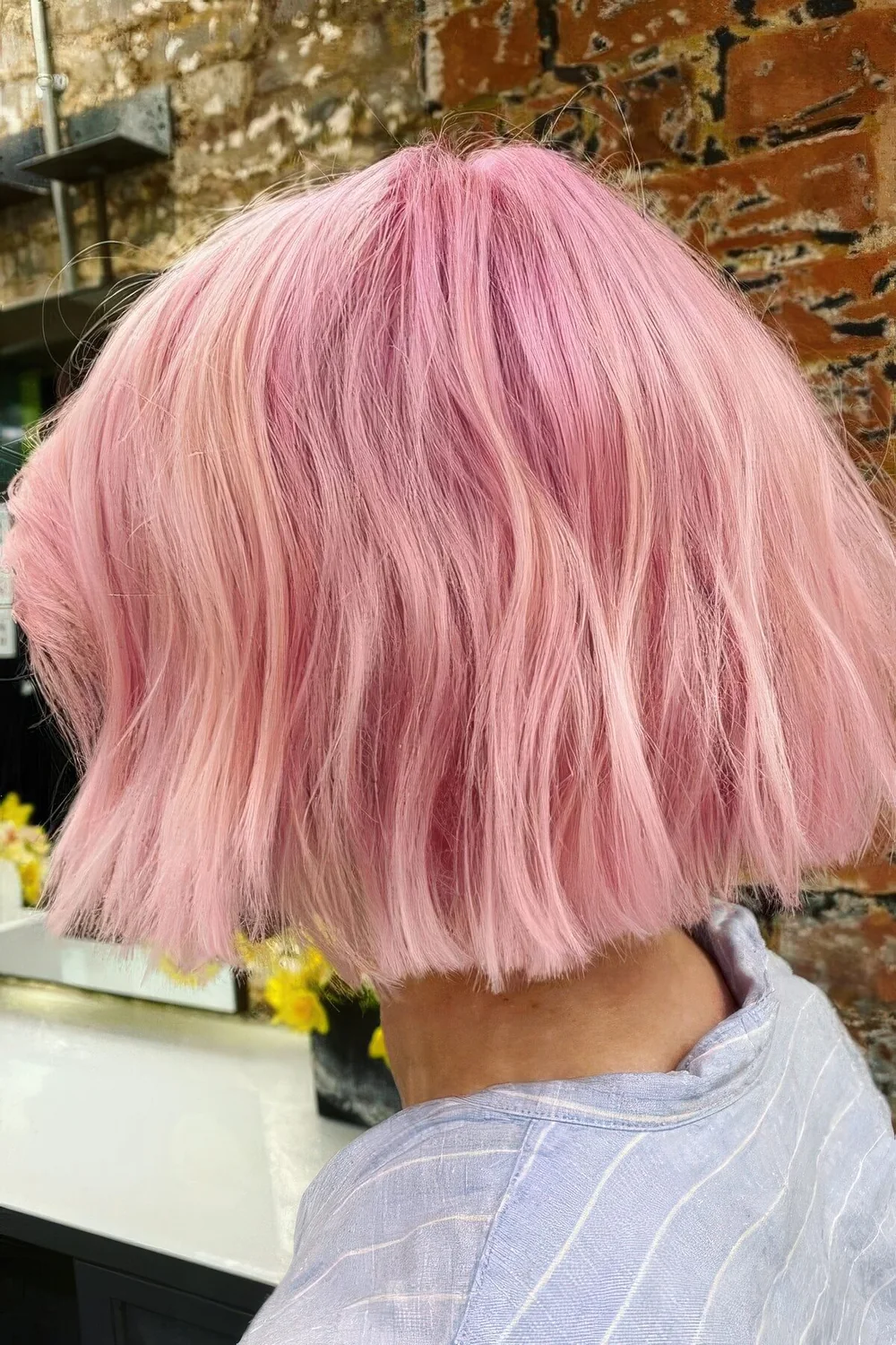 Bubblegum pink midi textural bob with a lot of volume and a bit of waves.