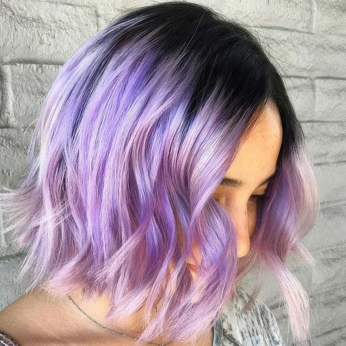 Photo showing lilac wavy bob with a black root, with the hairstyle clearly visible.