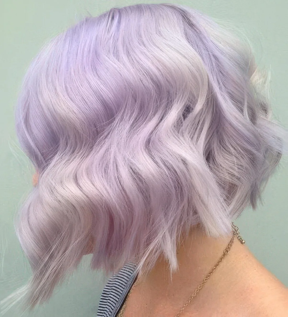 Lilac wavy bob with white highlights and a lot of volume.