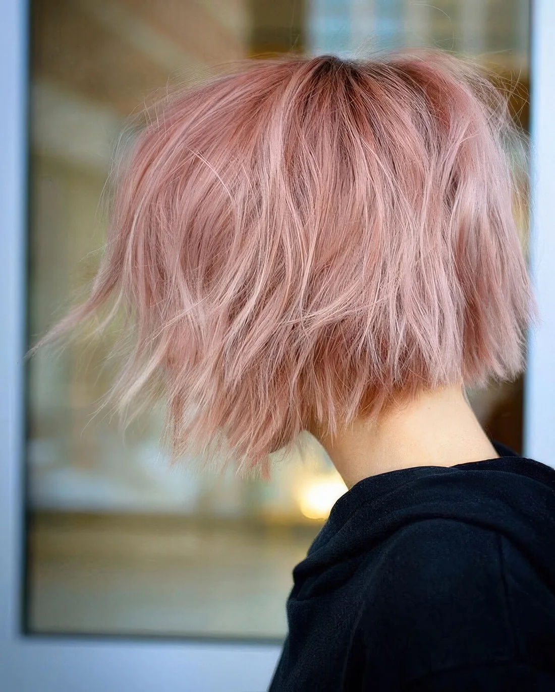 Jaw-length pink wavy and textured bob with a darker root.