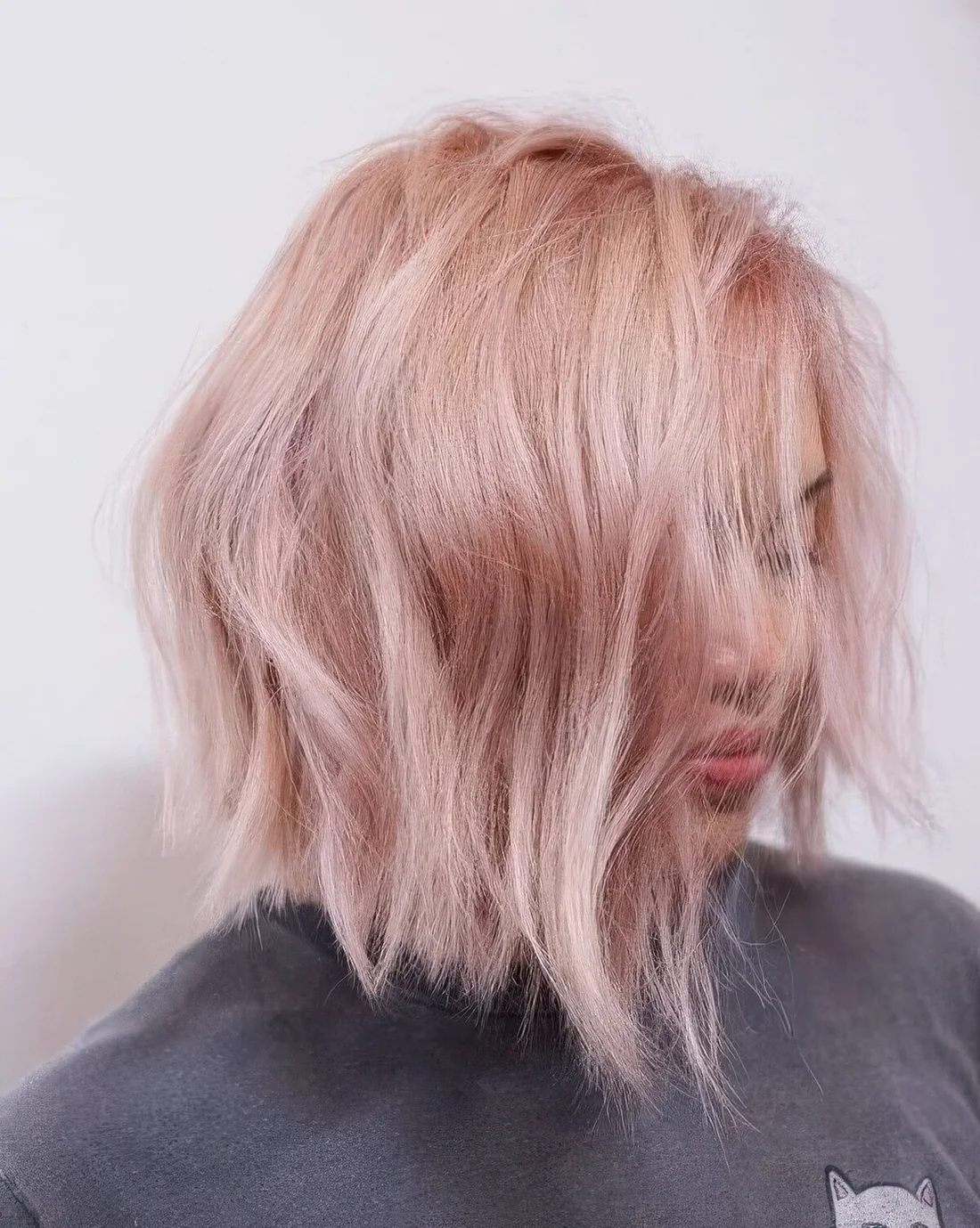 Textural blush pink wavy bob with side part.