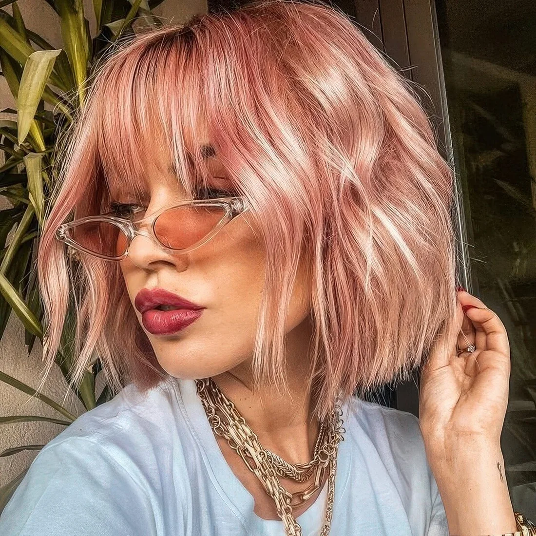 Pink midi length bob with outgrown wispy bangs and waves.