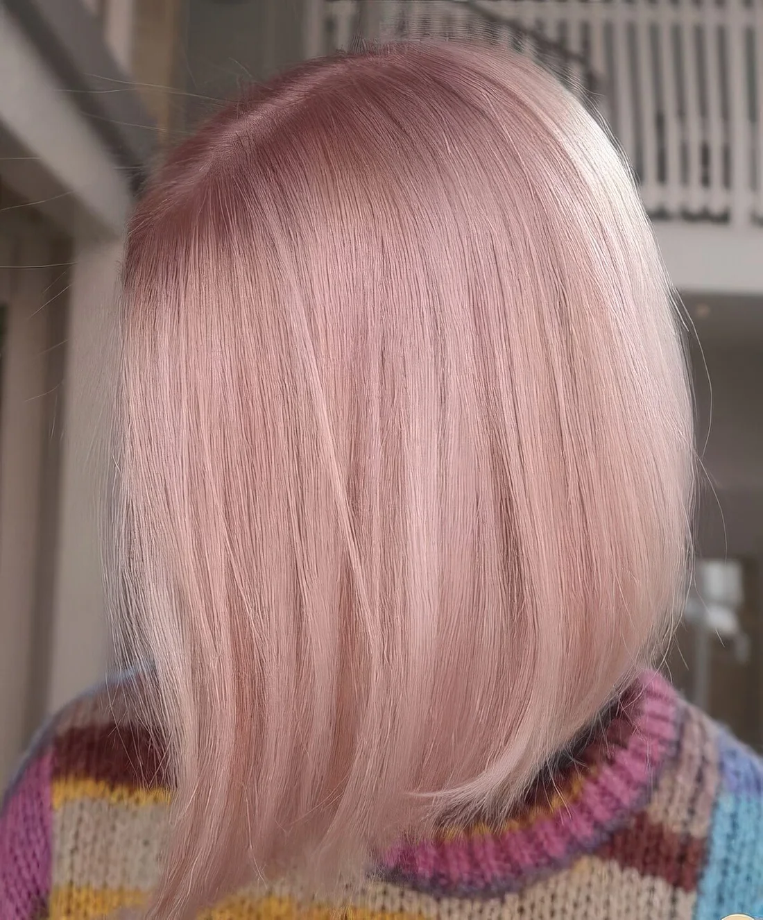 Shiny light pink bob with center part and straight hair.
