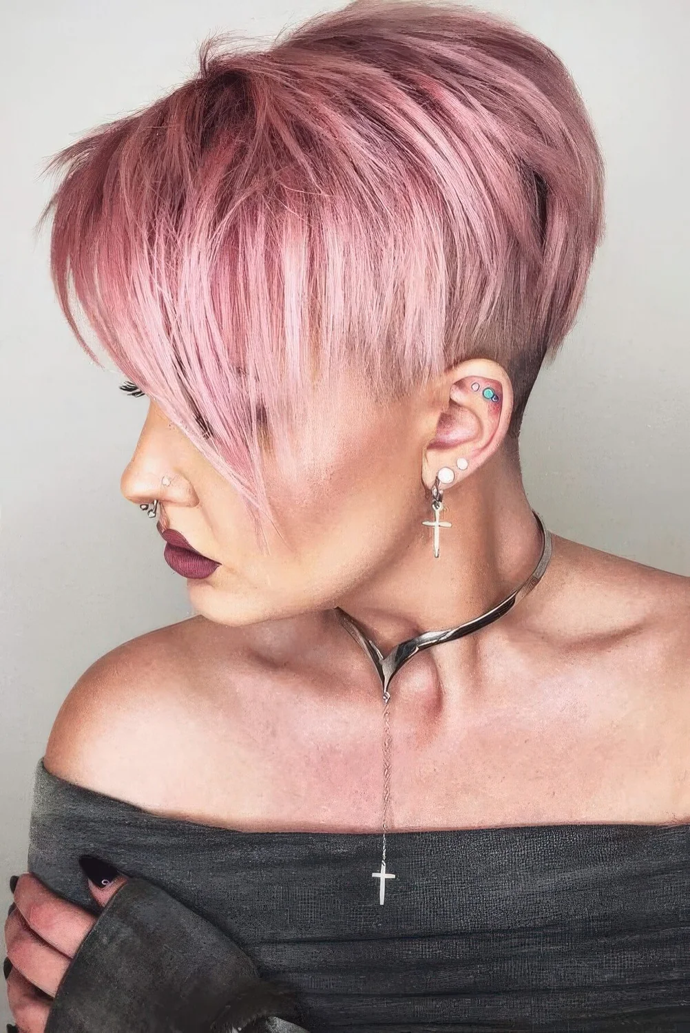 Long layered pink pixie with an undercut and long bangs.