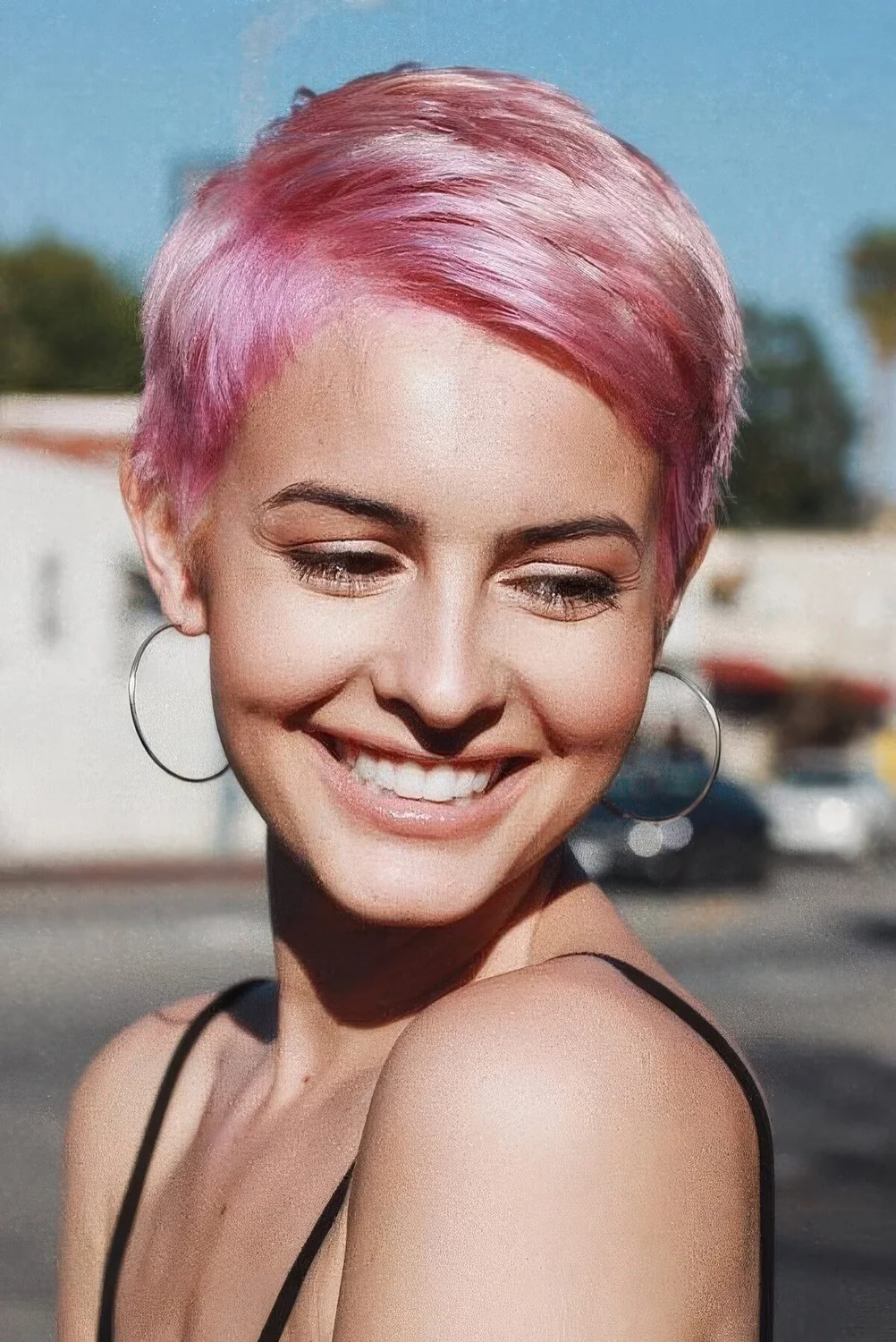 Pastel pink pixie haircut with short yet thick hair and side bangs.