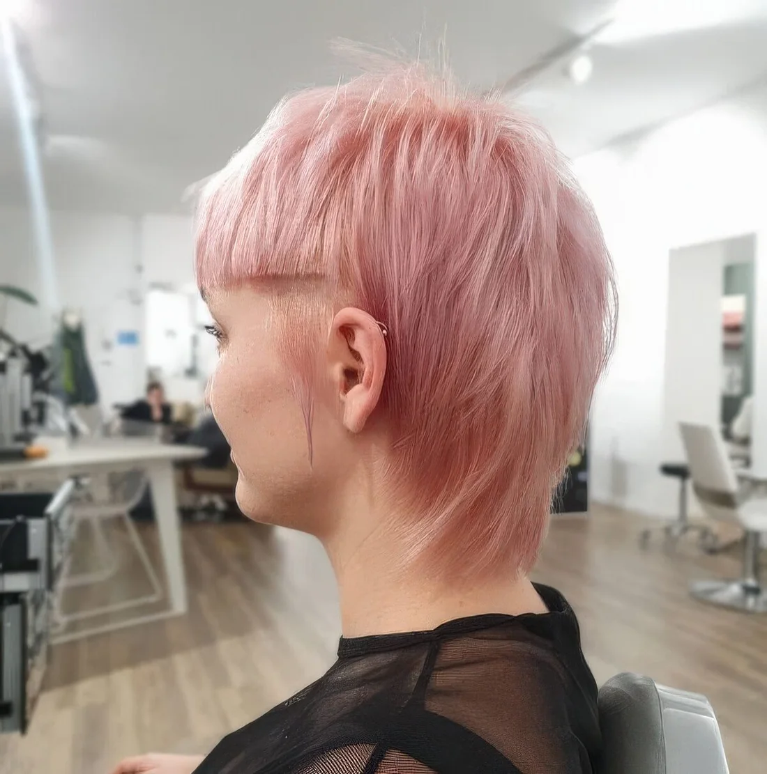 Pastel pink straight hair short mullet with sharp line bangs.