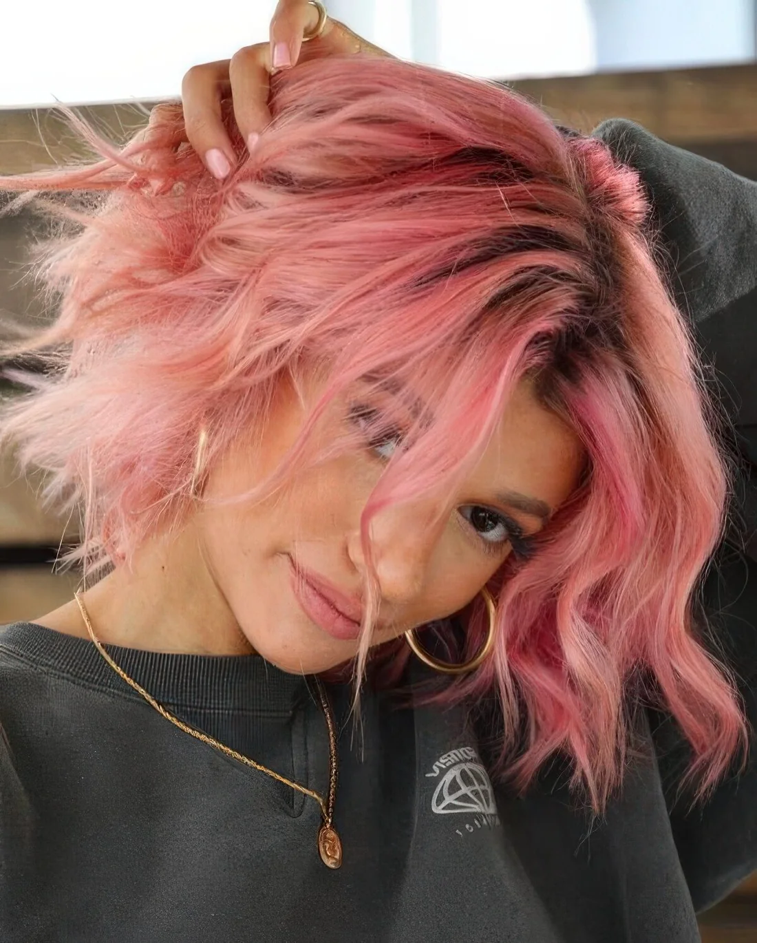 Hot pink wavy bob with a darker root and messy waves.
