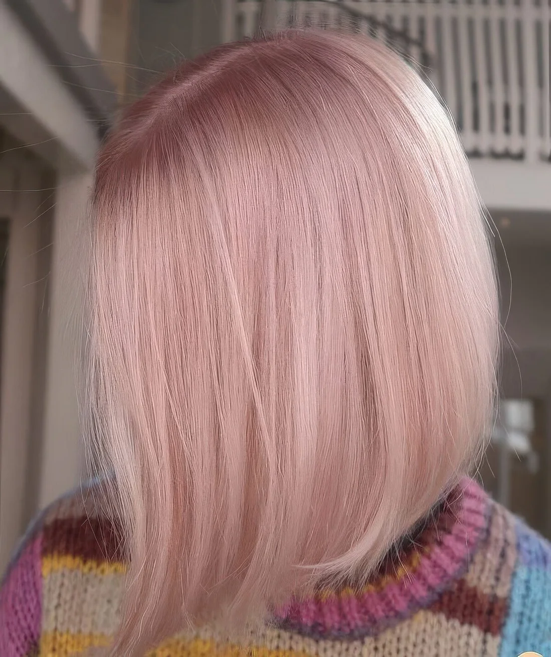 Shiny light pink bob with center part and straight hair.
