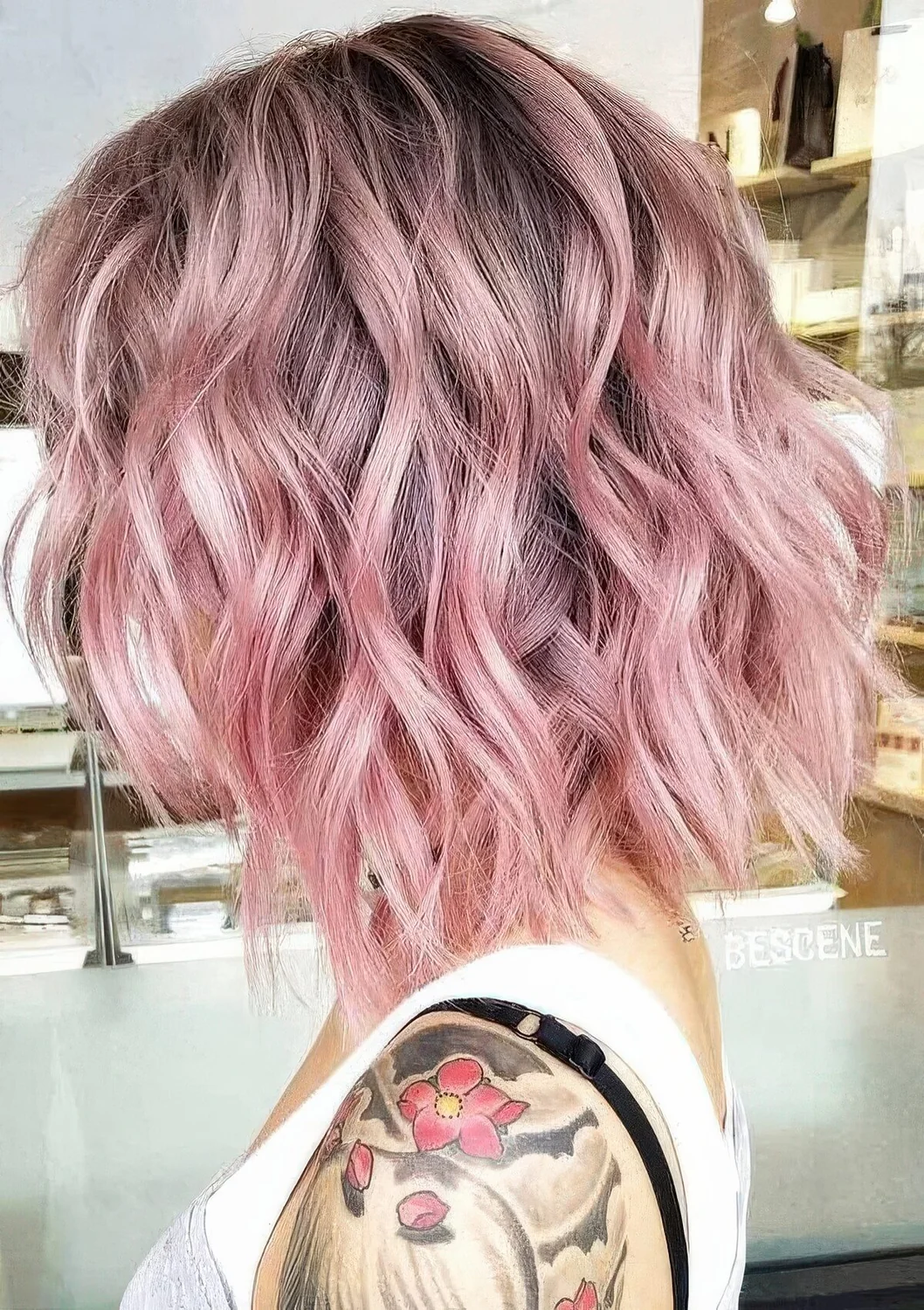 Lob haircut with waves done in pastel pink, with a darker root.