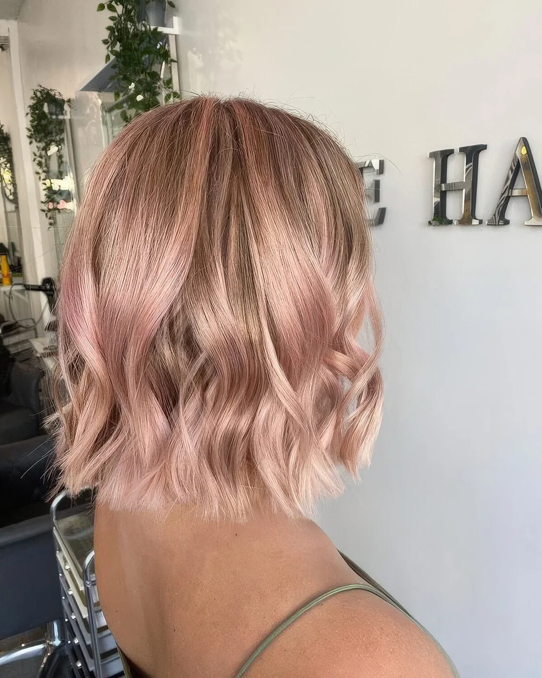 Long blonde bob with delicate blush pink balayage and a bit of waves.
