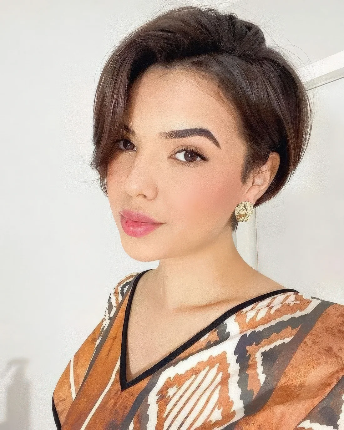 Photo showing dark brunette pixie side part, with the hairstyle clearly visible.