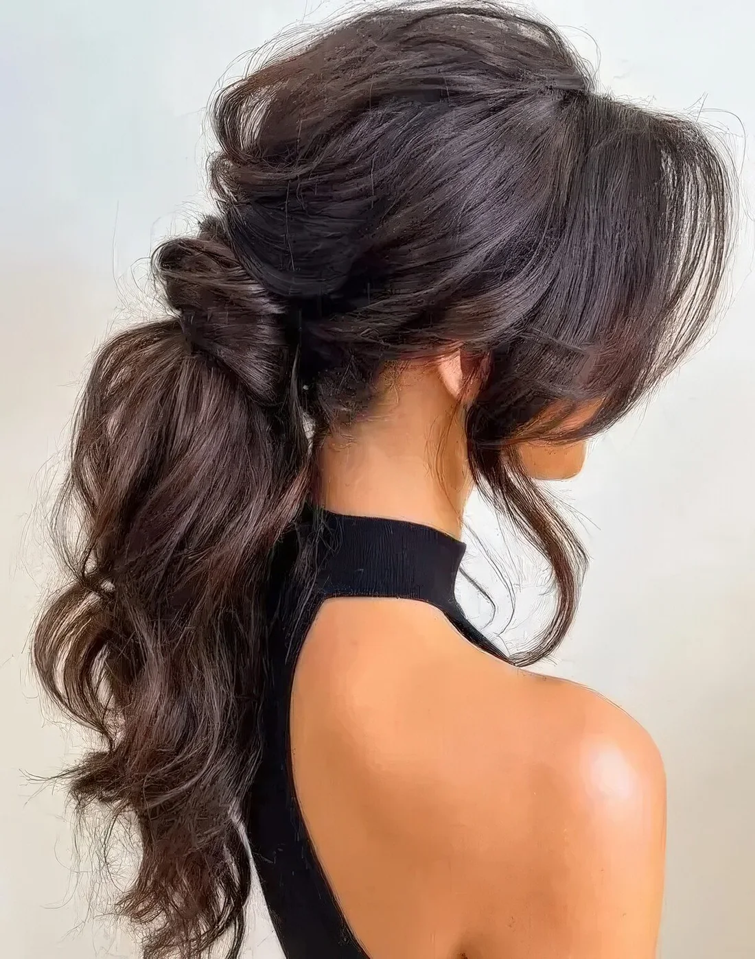 Jaw dropping wavy messy low ponytail with a messy volume on top, locks framing the face.