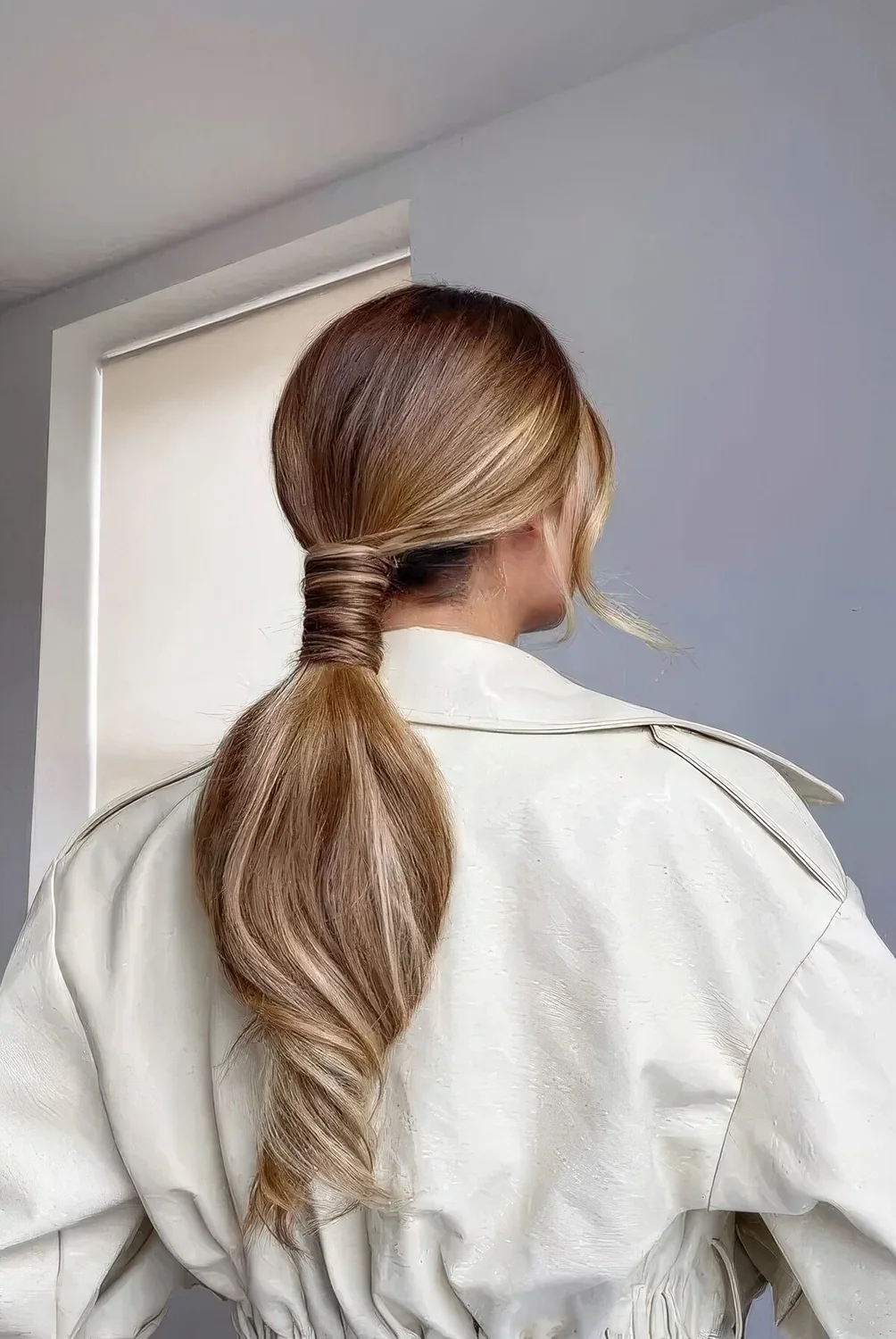 Low ponytail with a sleek top, a volumetric ponytail and face-framing hair.